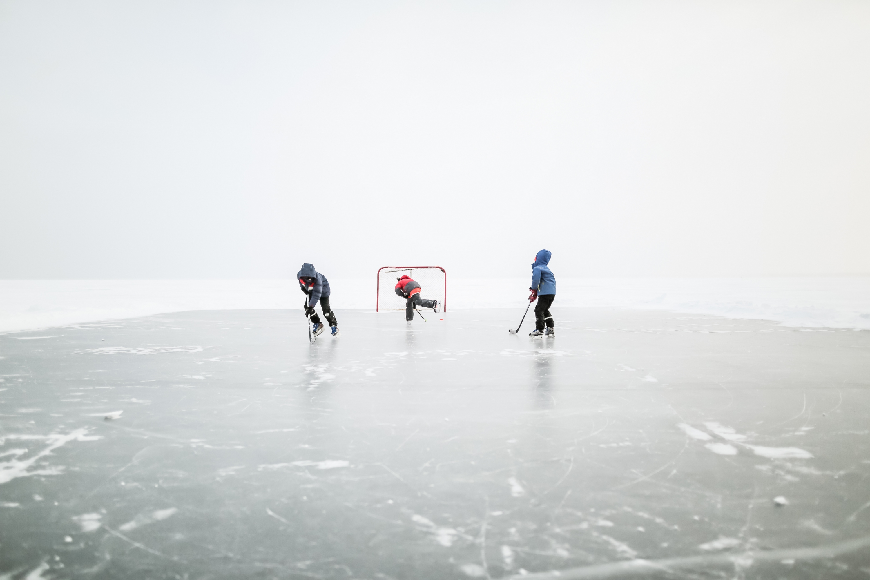 Kids playing ice hockey on outdoor rink