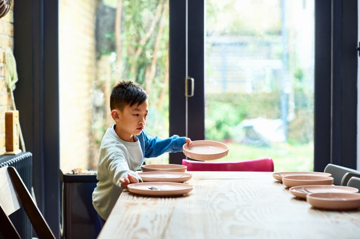 Young boy setting table for lunch
