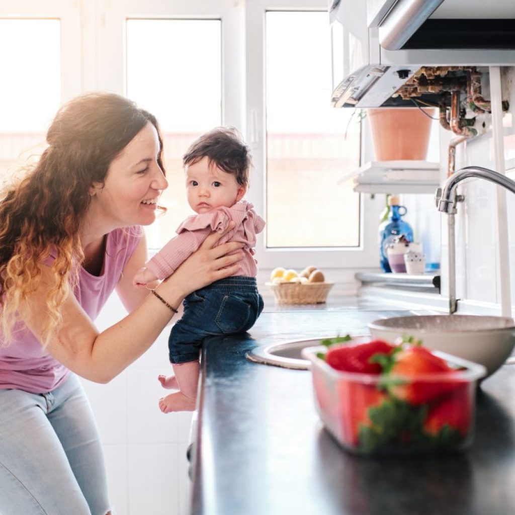 Mom holding baby on counter.