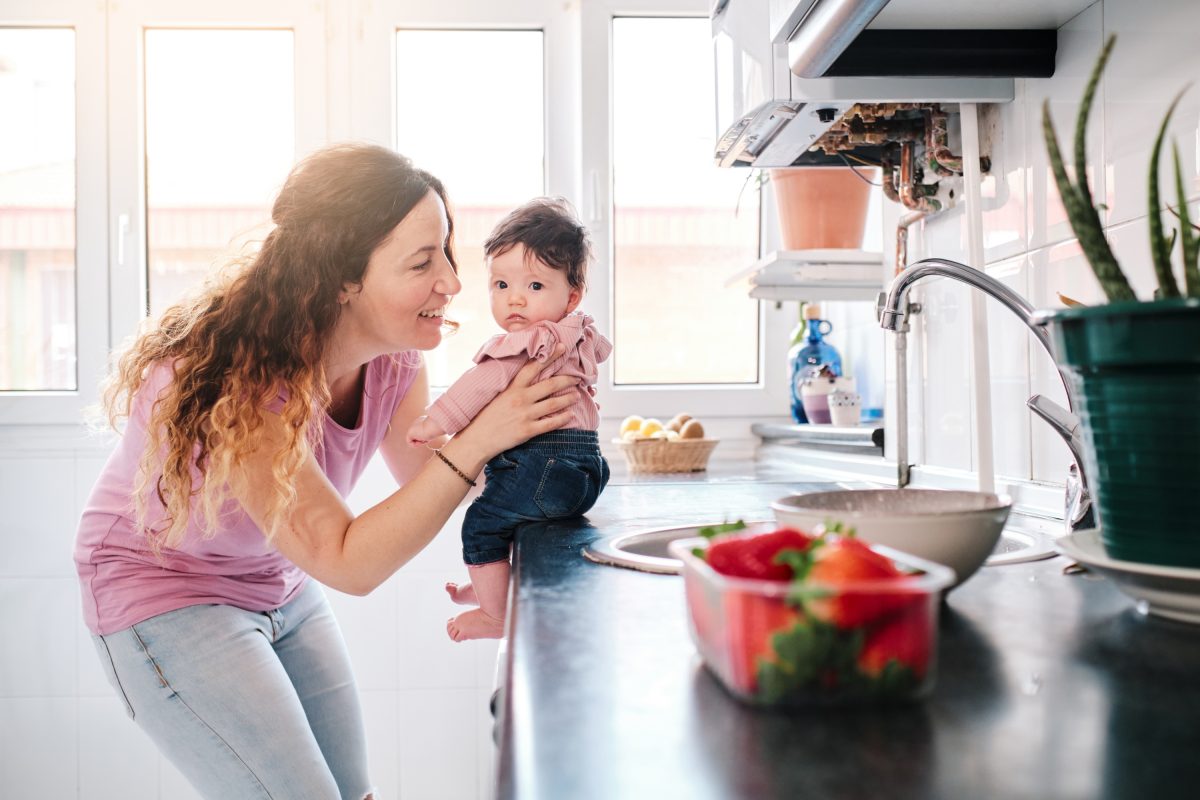 Mom holding baby on counter.