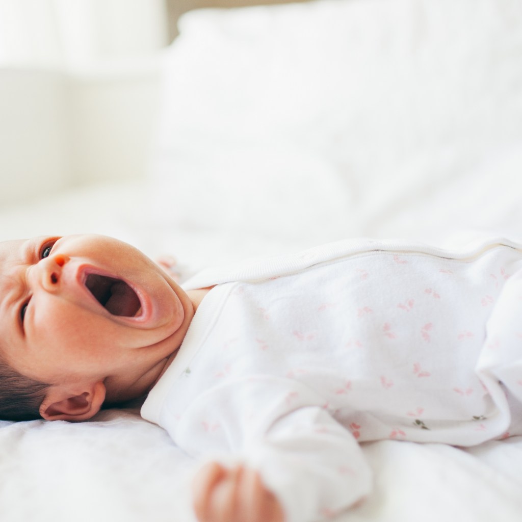 Baby yawning in crib