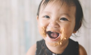 Baby with peanut butter on their face