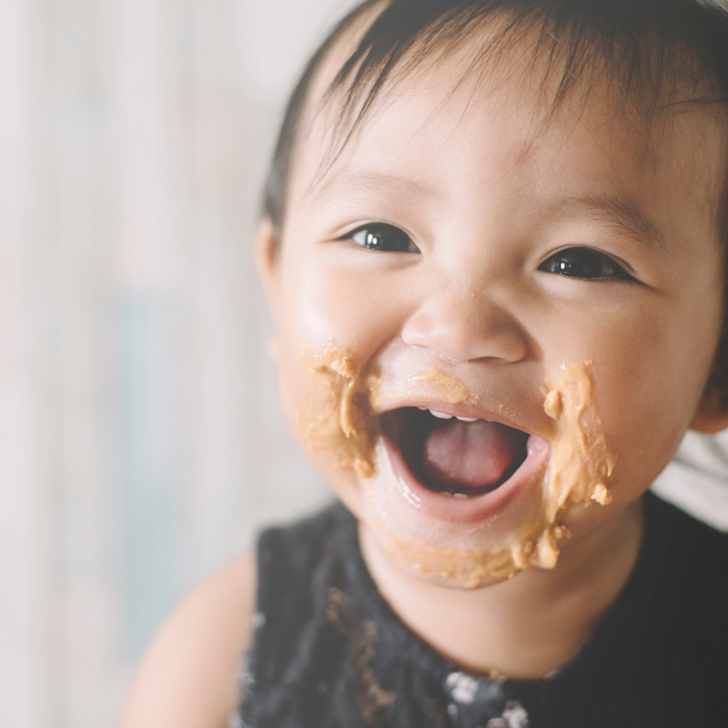 Baby with peanut butter on their face