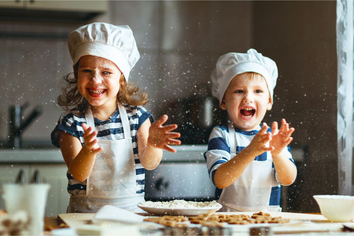 Two kids having fun baking in the kitchen.