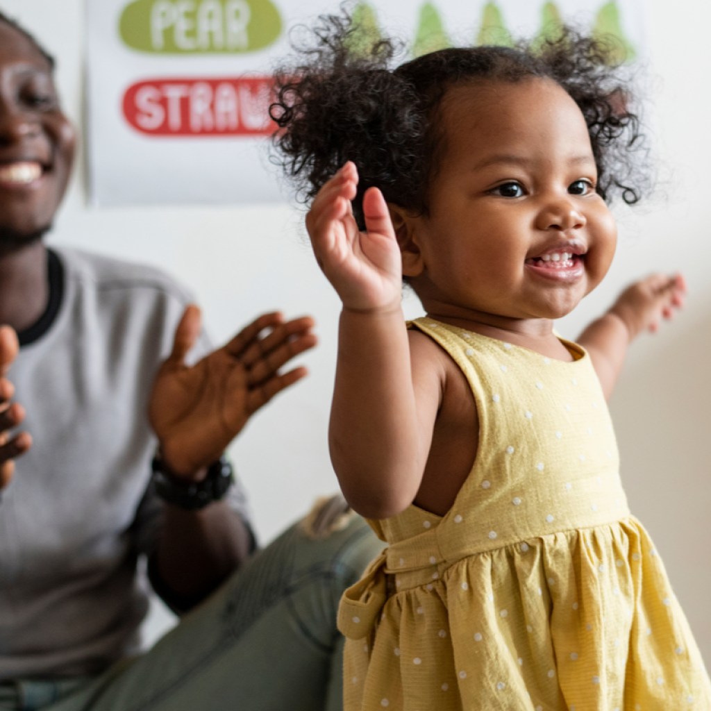 Toddler girl and her dad having fun with music and movement activity.
