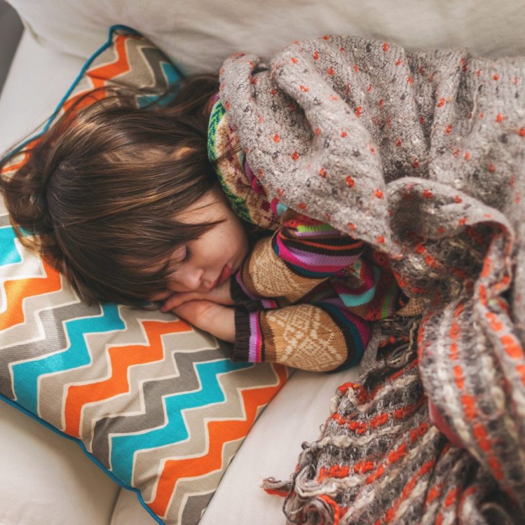 Sick toddler sleeping on sofa