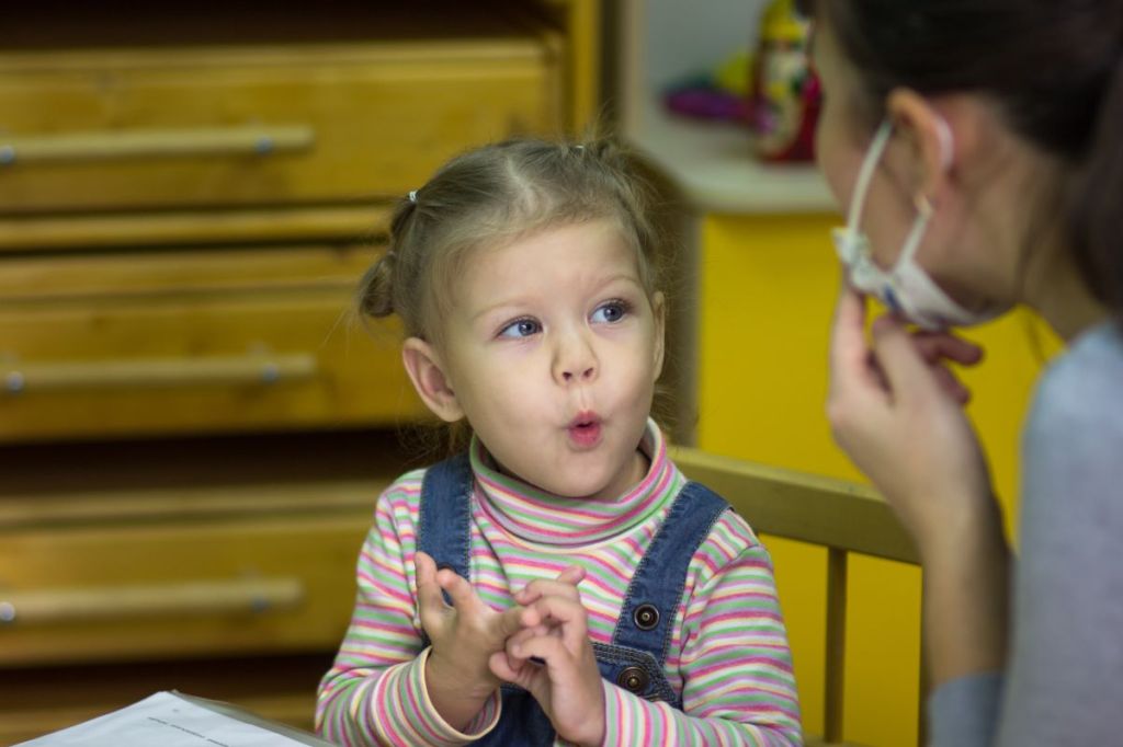 Speech therapist working with toddler girl