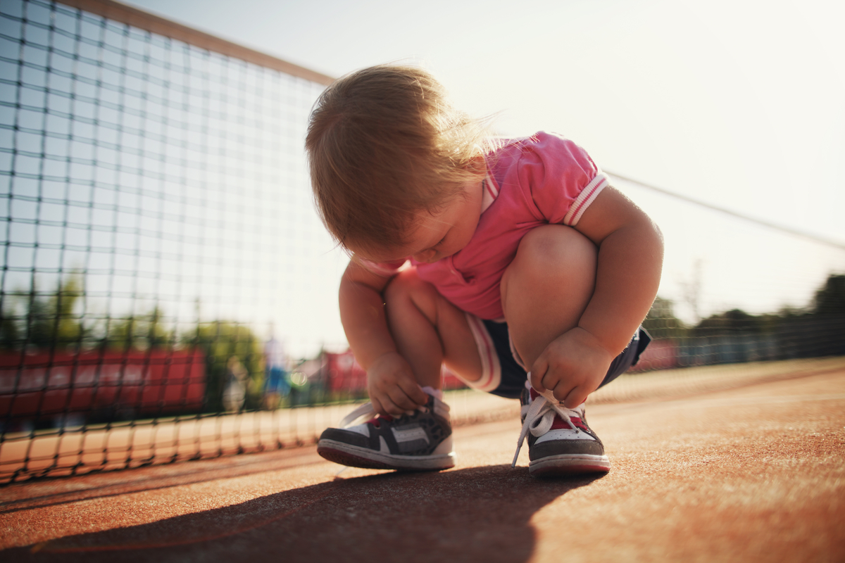 Toddler girls fascinated by her shoe laces