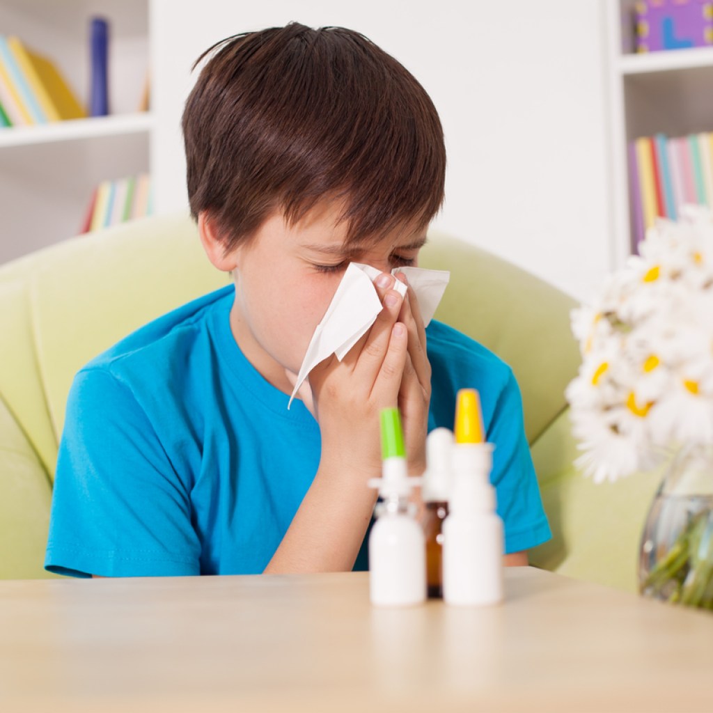 boy using nasal sprays and eye drops to help ease allergy symptoms