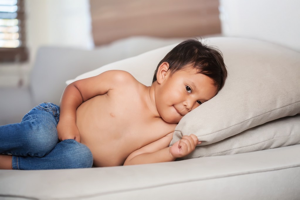 upset toddler laying on couch