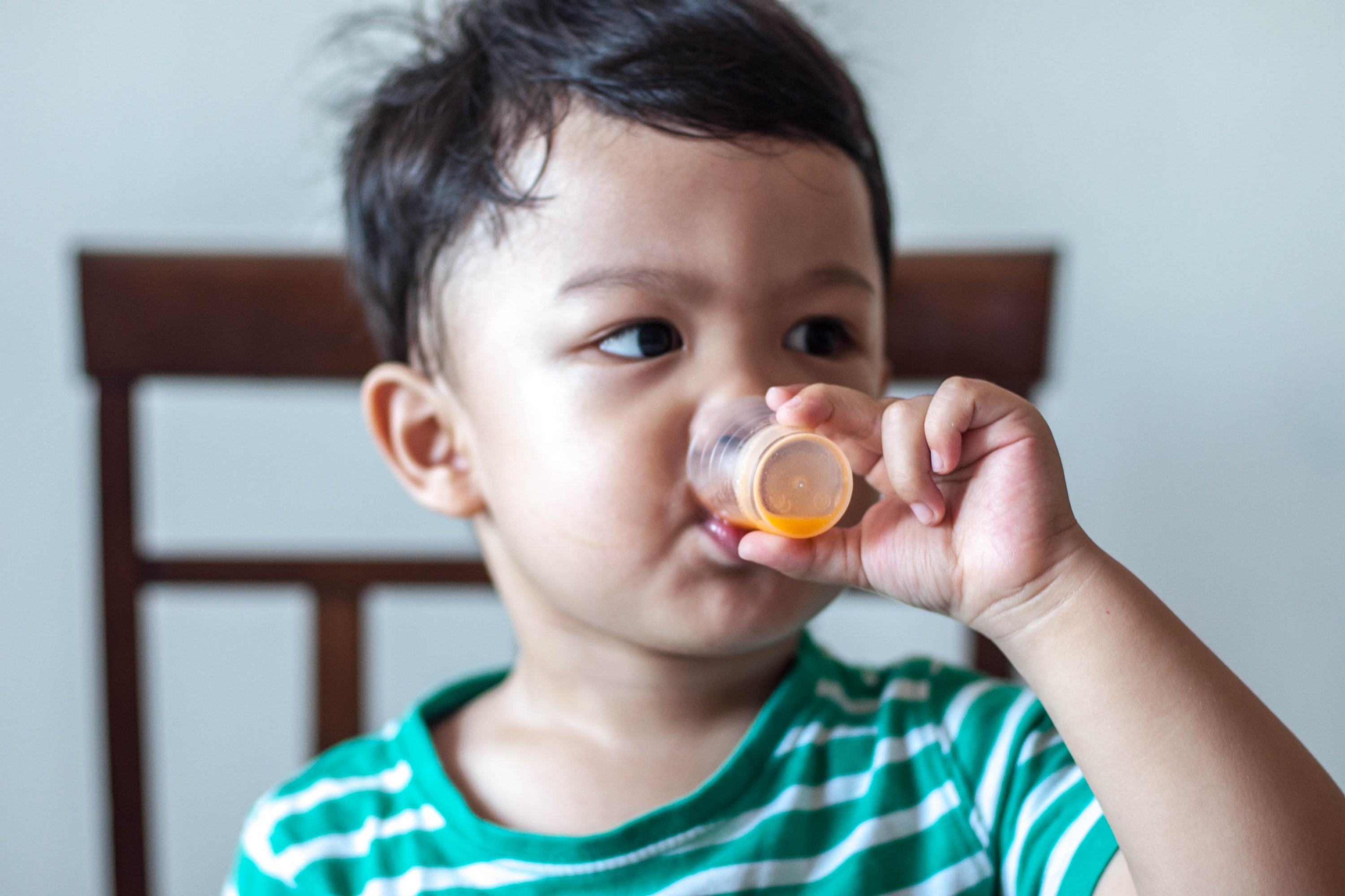 Toddler drinking liquid medicine at home