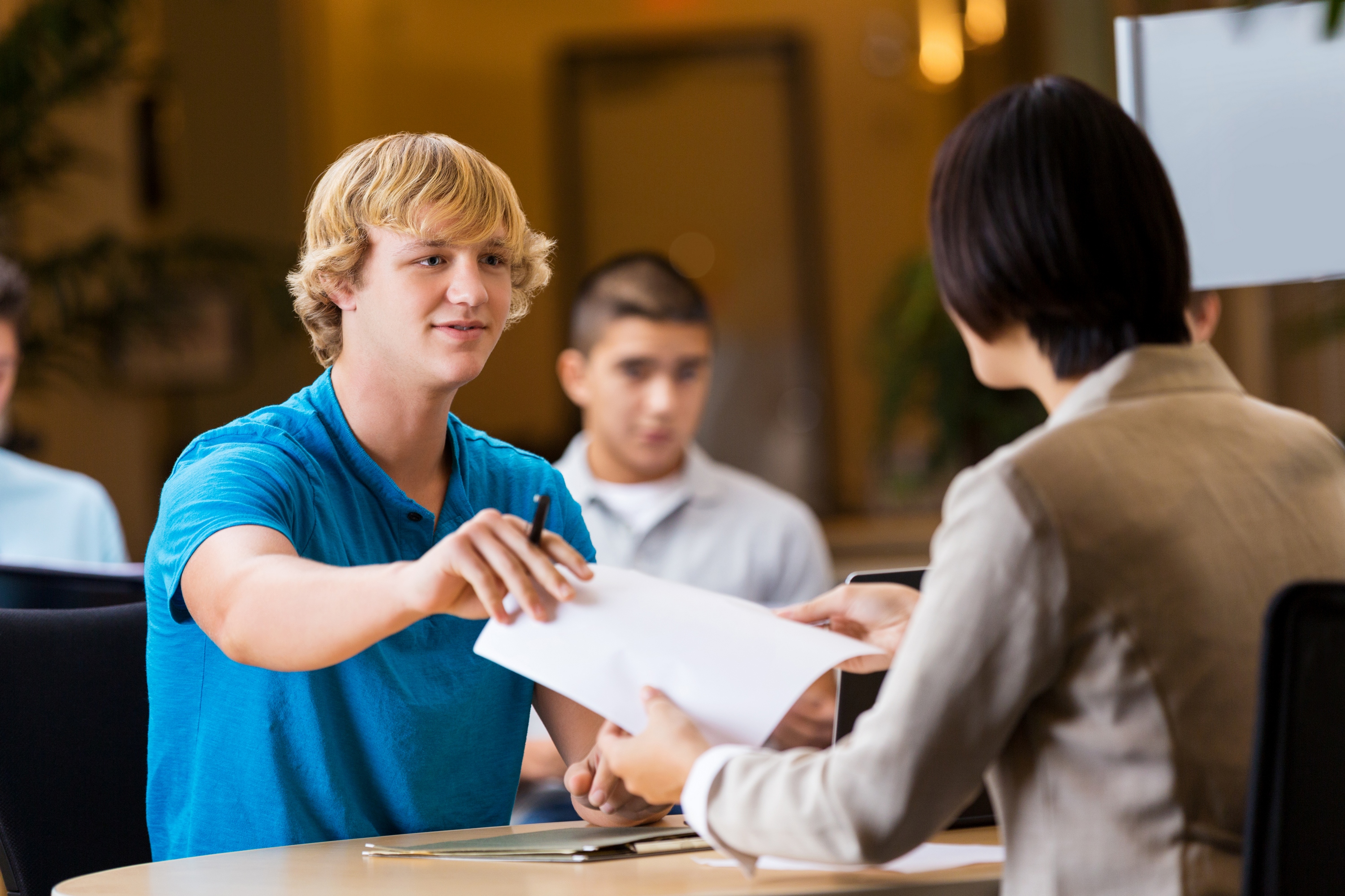 teen handing in a job application