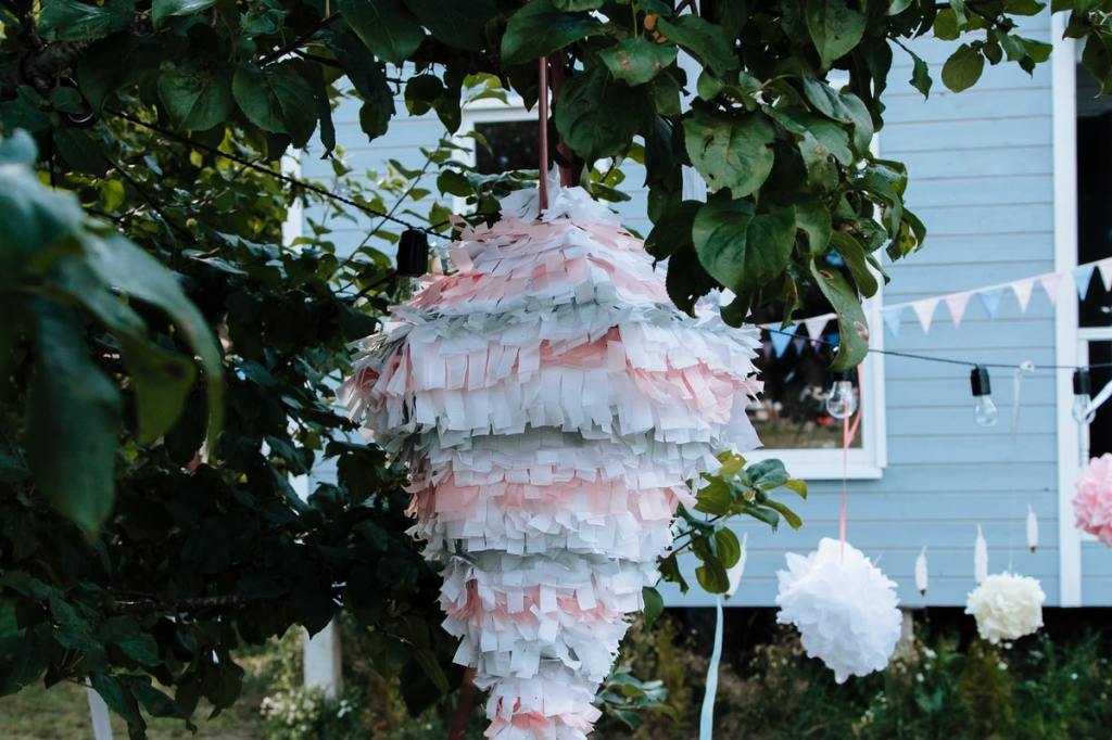 A pink and blue pinata hanging from a tree