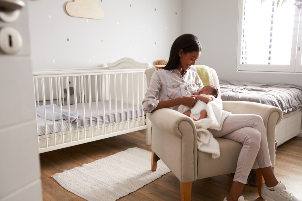 A mother holding her baby in the nursery.