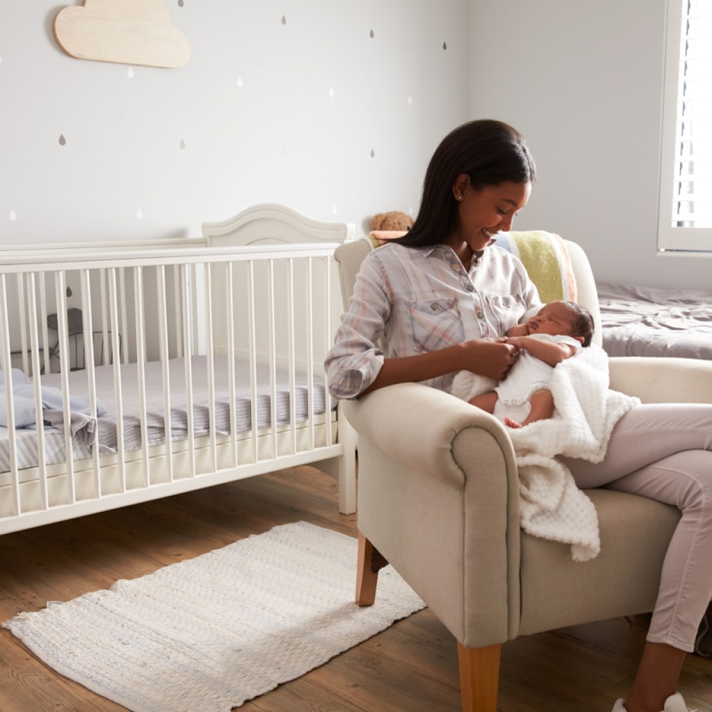 A mother holding her baby in the nursery.