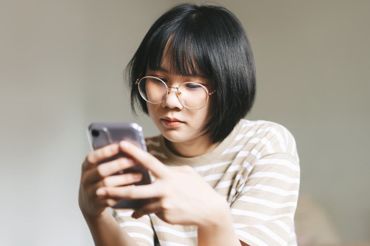 teen girl using her smartphone for an online therapy session