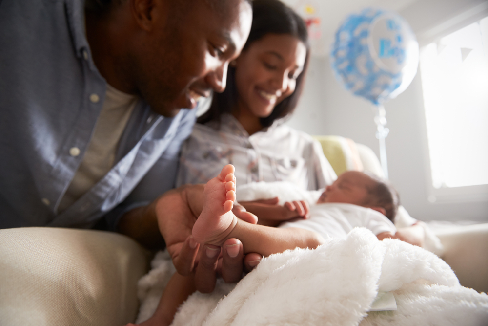 Parents smiling while holding newborn.