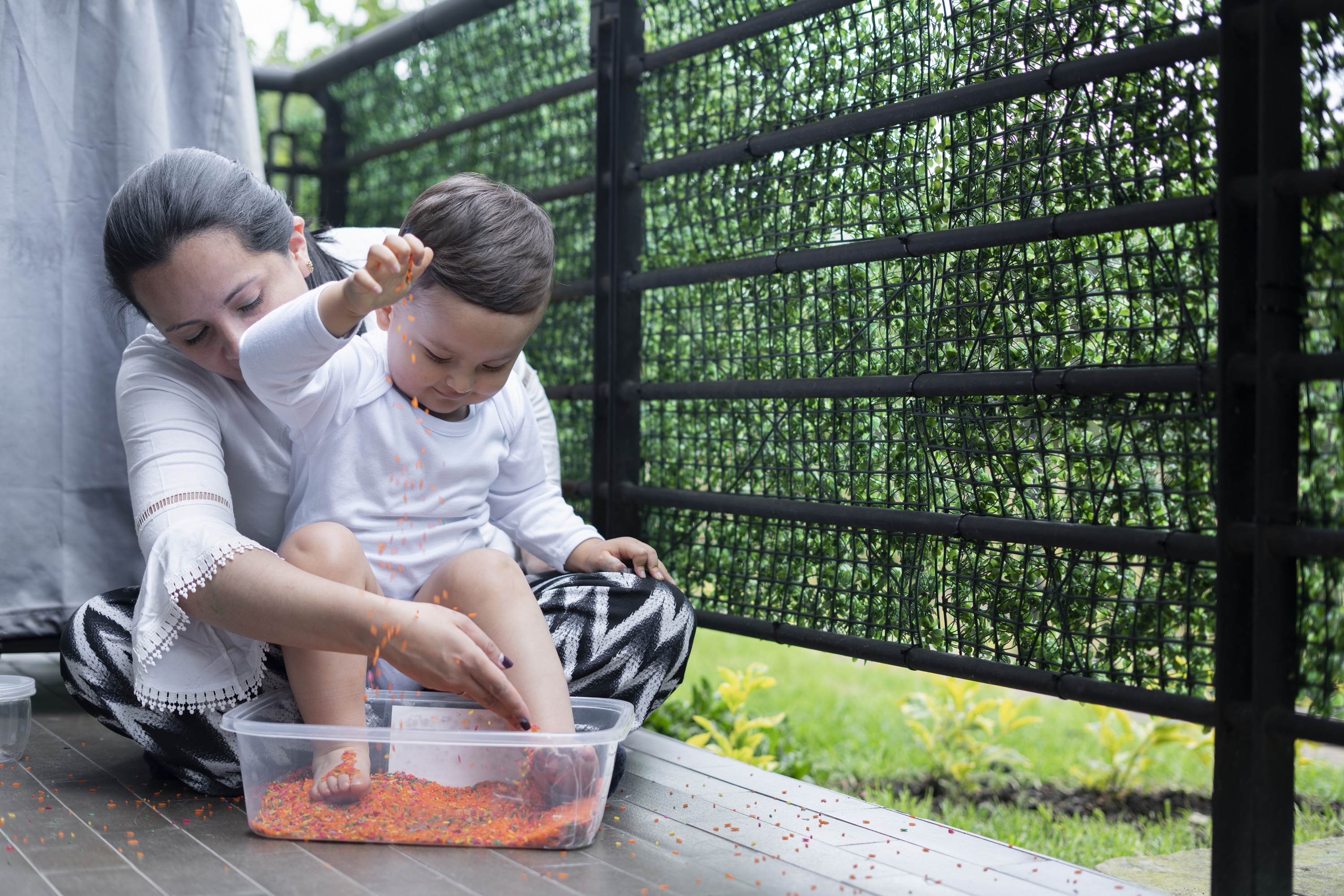 Mother and child playing with sensory bin