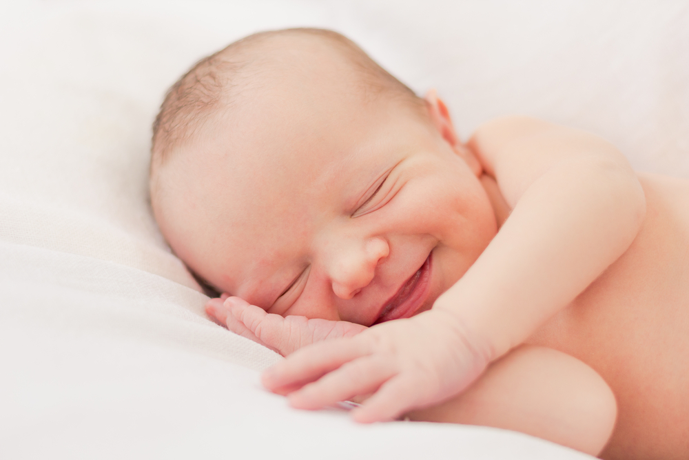 Newborn smiling while asleep.