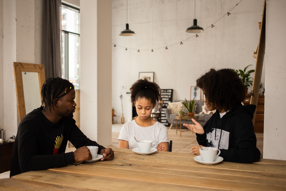 Parents sitting on either side of teen and scolding her