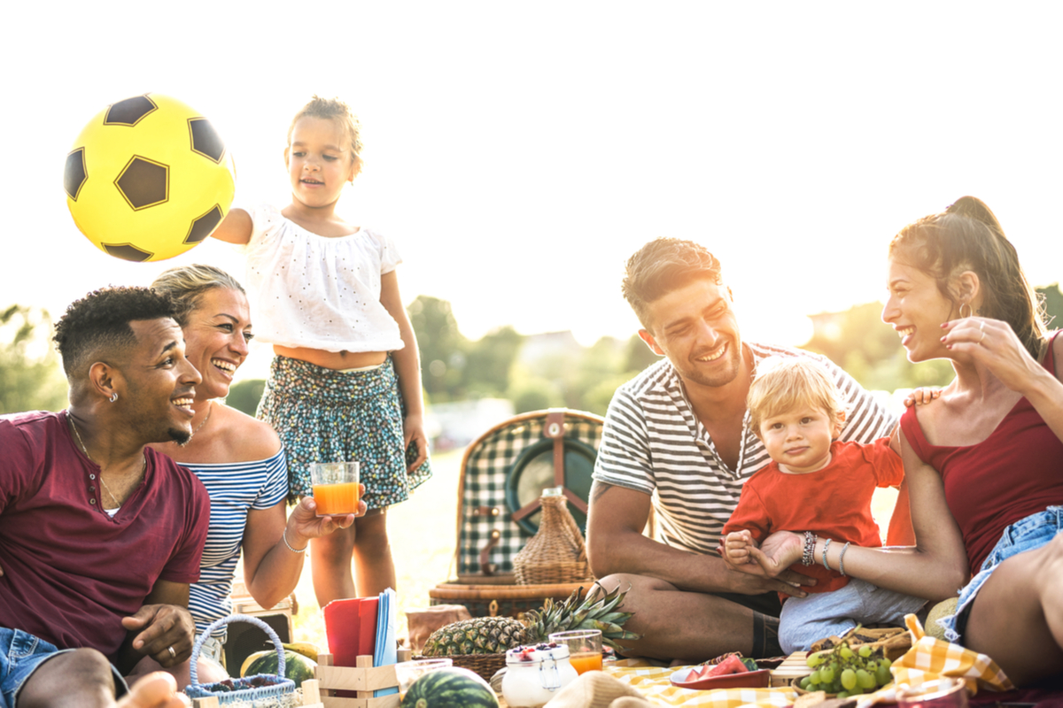 A group of families sitting around the table together at a campsite
