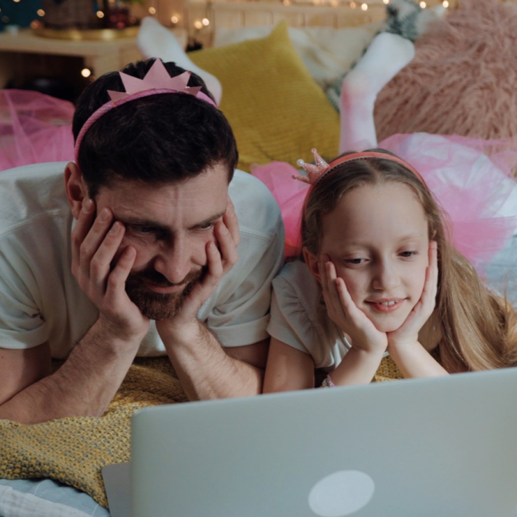 A father and daughter watching a movie dressed up