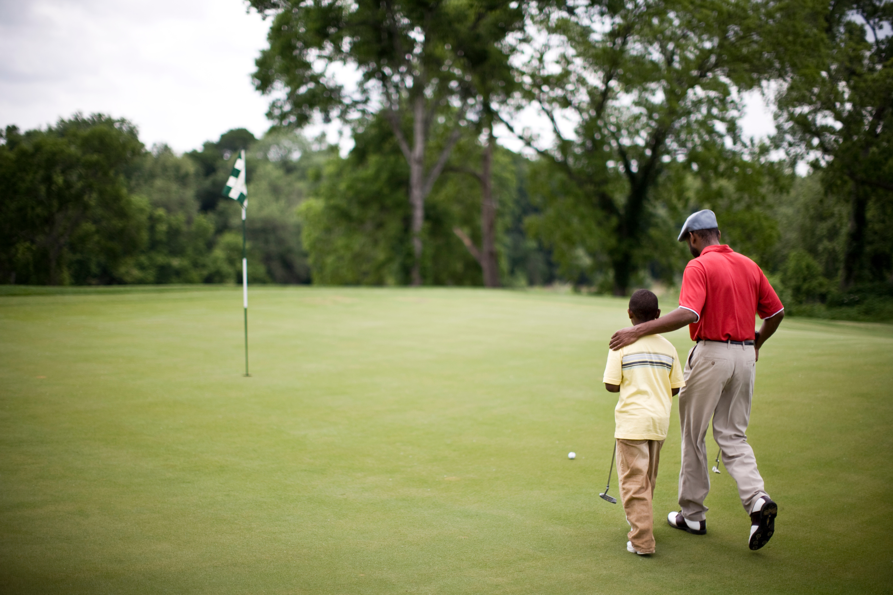 Father and son walking on the golf course on Father's Day