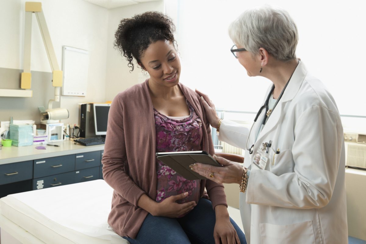 A pregnant woman talking to her health care provider.