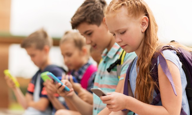 Group of tweens all using cellphones.