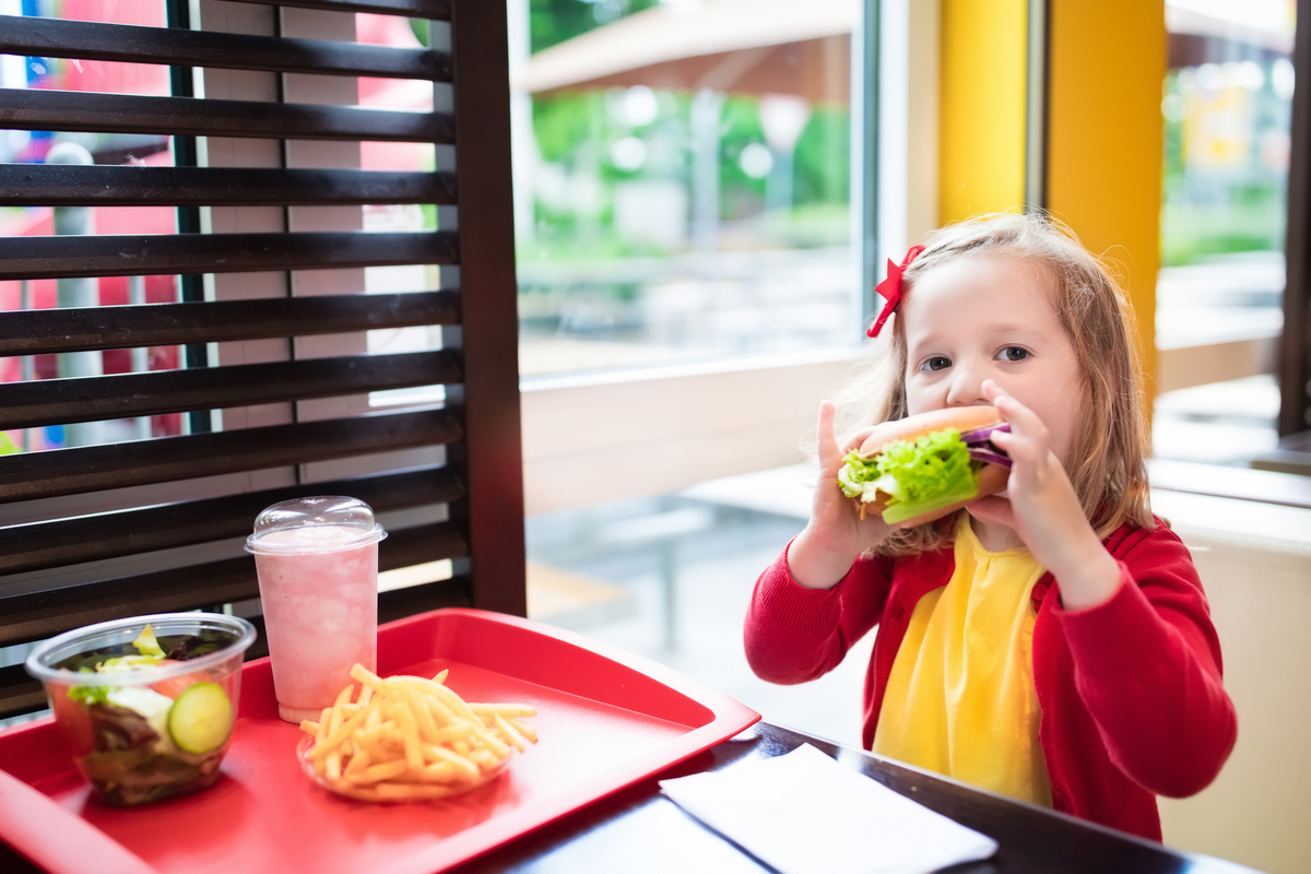 A young girl eating a fast-food meal