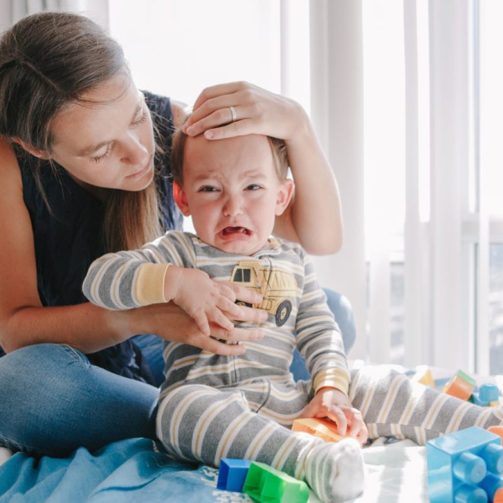 A mother trying to calm down her angry toddler.