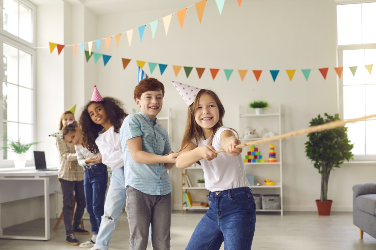 Kids playing tug-of-war at a birthday party.