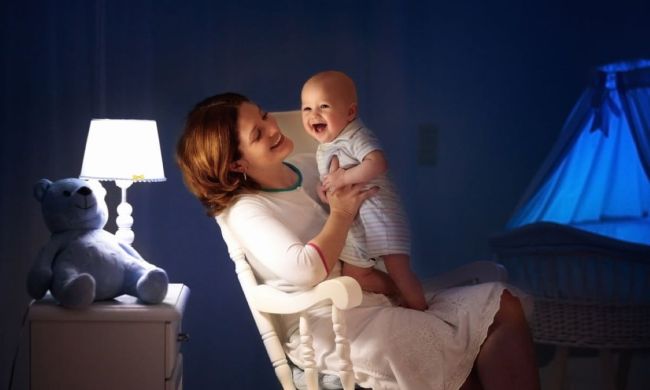 Mom sitting in a rocking chair holding a smiling baby