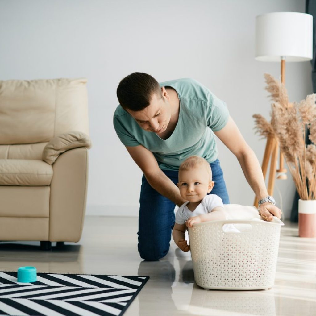 A parent pushing their baby in a laundry basket