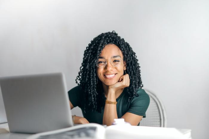 Teen girl sitting at computer smiling