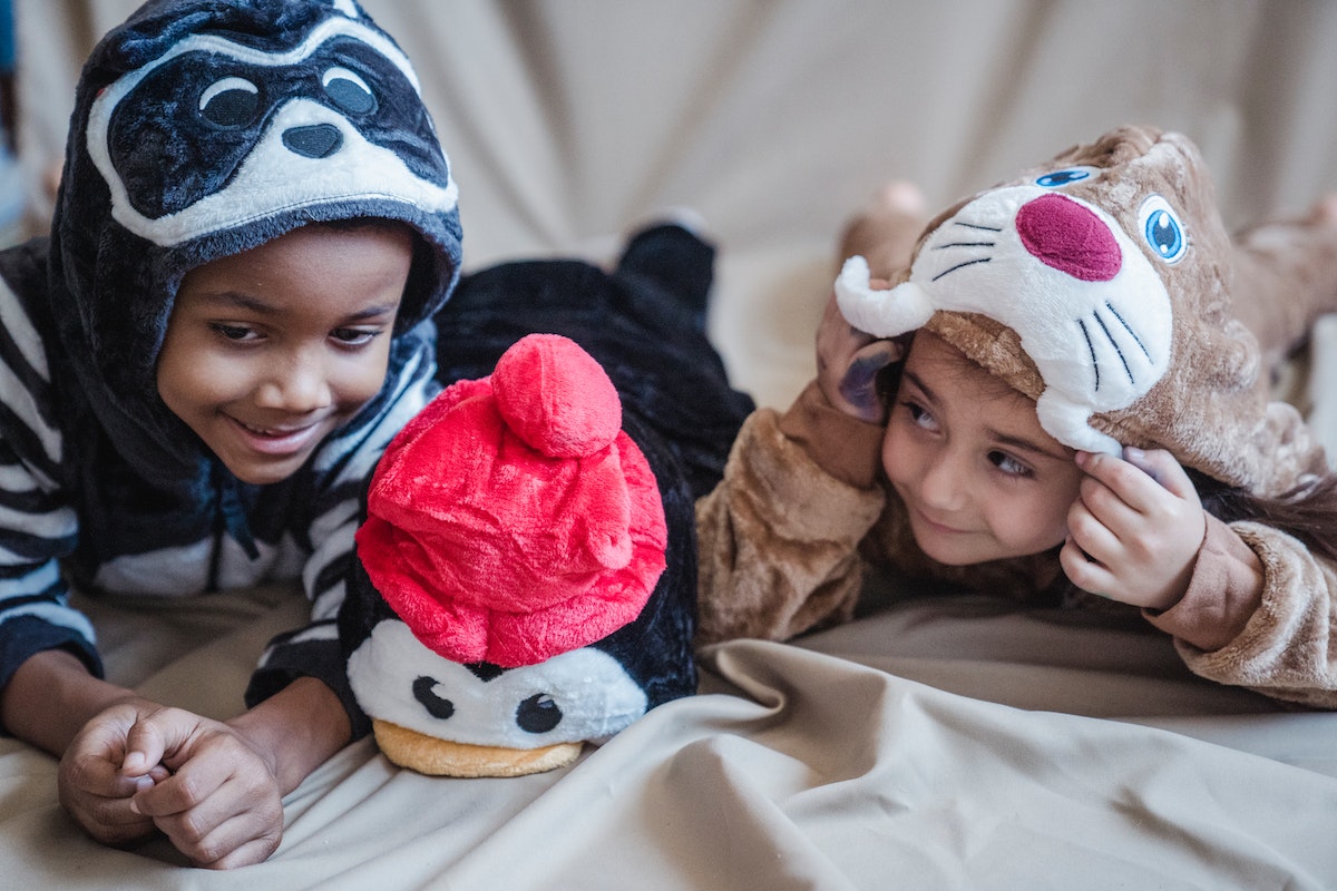 Two kids wearing animal costume onesies