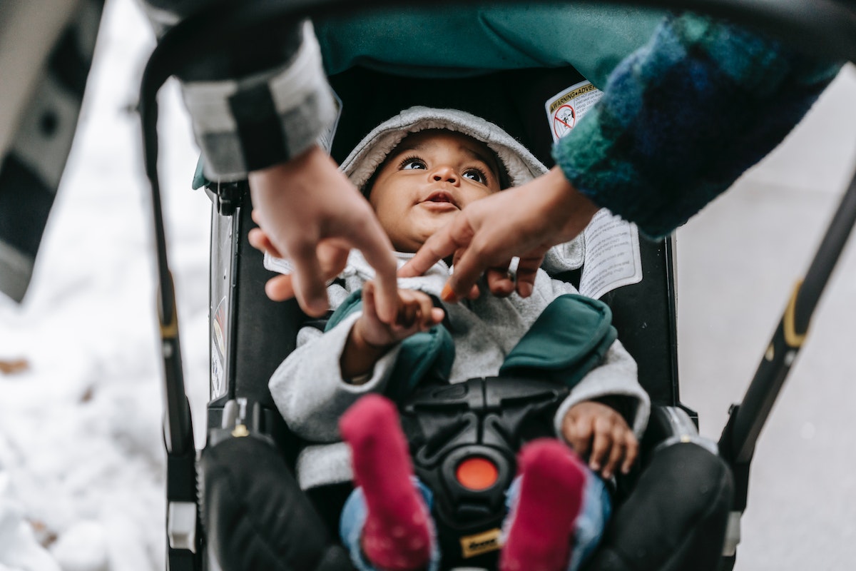 Parent playing with baby in stroller