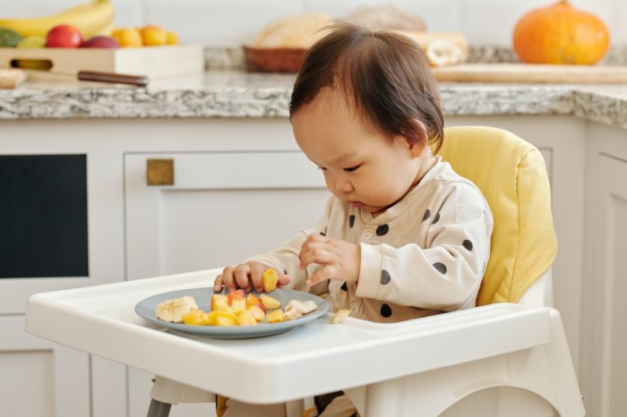 Baby eating solids in highchair