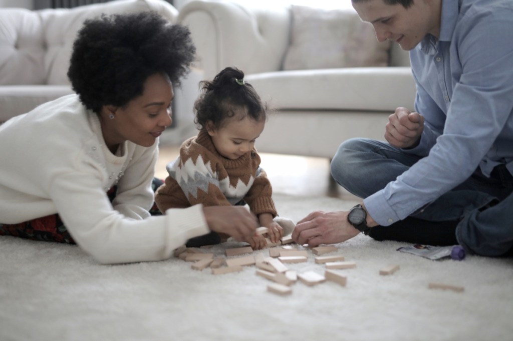 Two parents playing with blocks with a child