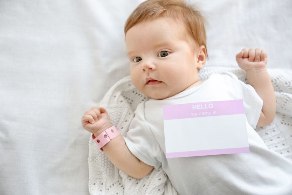 Baby girl with a "hello my name sign is" on her onesie