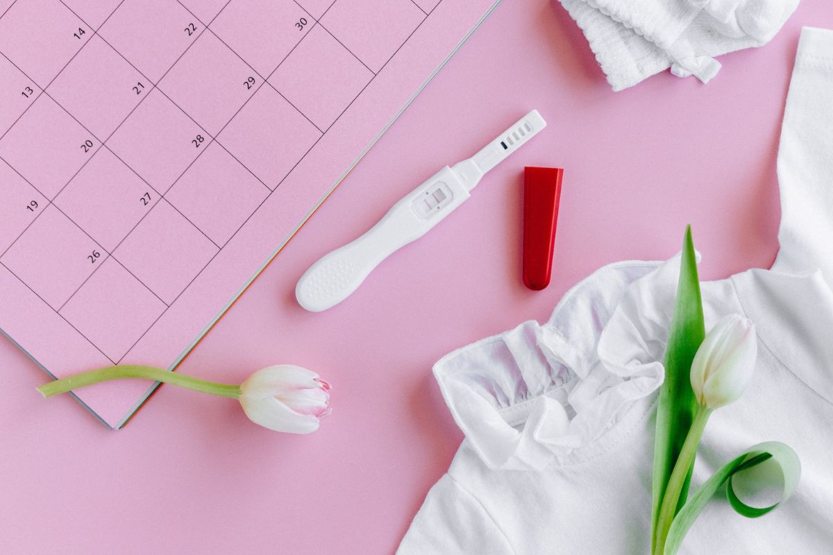 A pregnancy test with flowers and a calendar