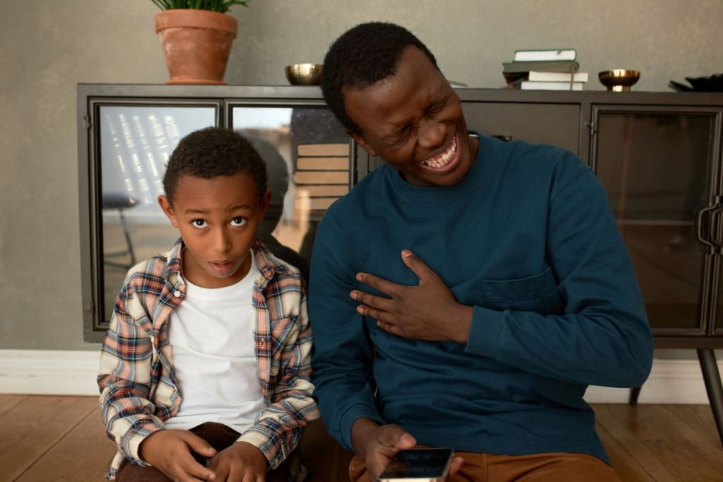 Father laughing at one of his dad jokes and his son not