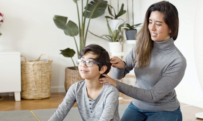 A mother combing her son's hair