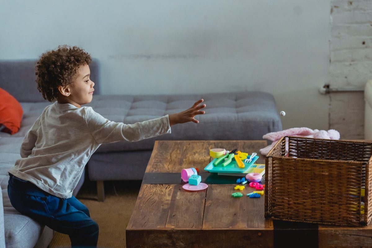 A child tossing toys in a basket