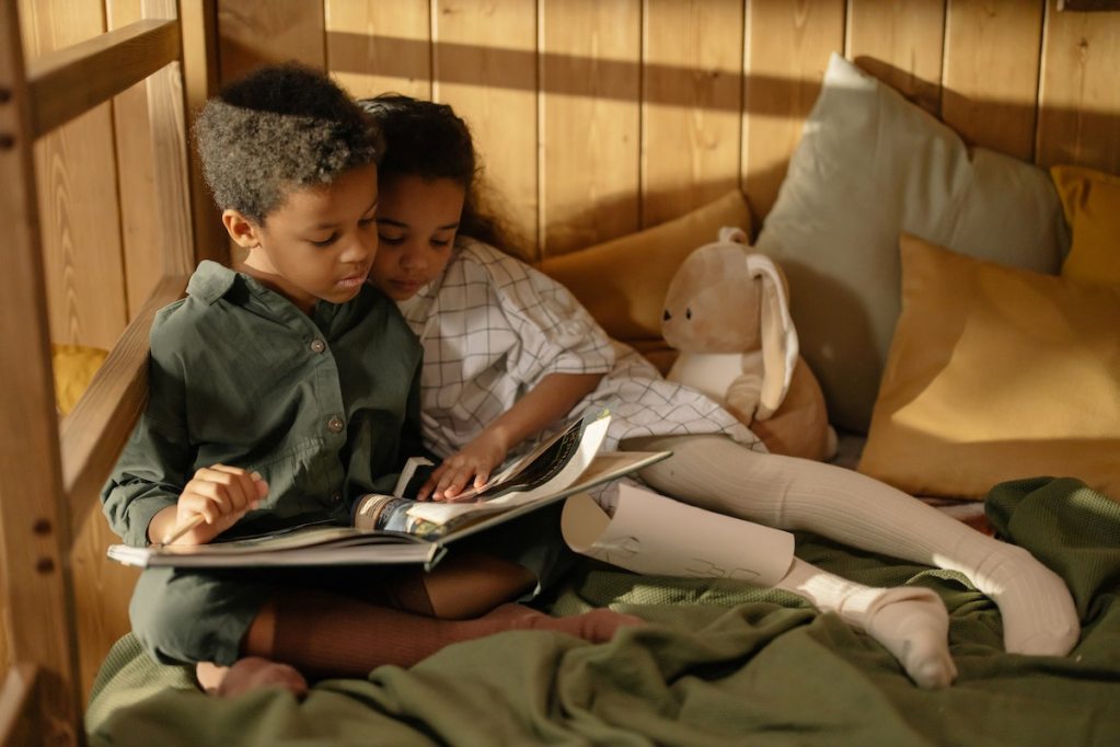 Two children reading in bed