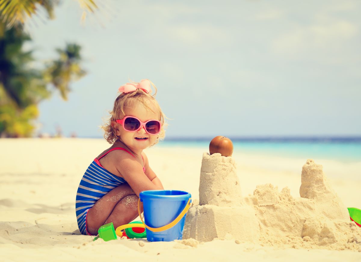 Little girl learning how to make a sandcastle