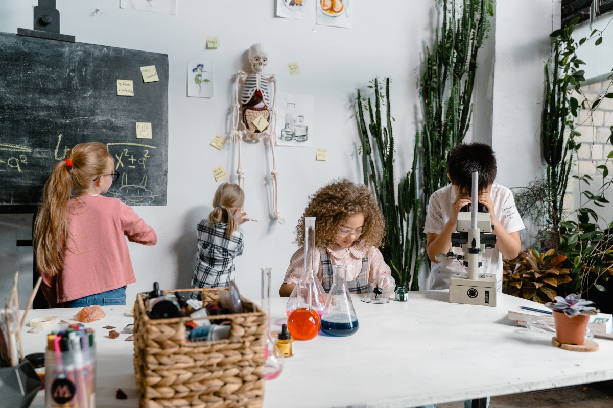 Kids in science room with chalkboard and microscopes