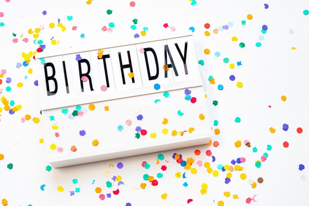 A light box with the word birthday on the top and confetti all around