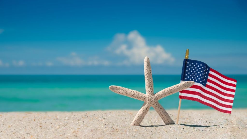 An American flag on a deserted beach signifying Memorial Day weekend