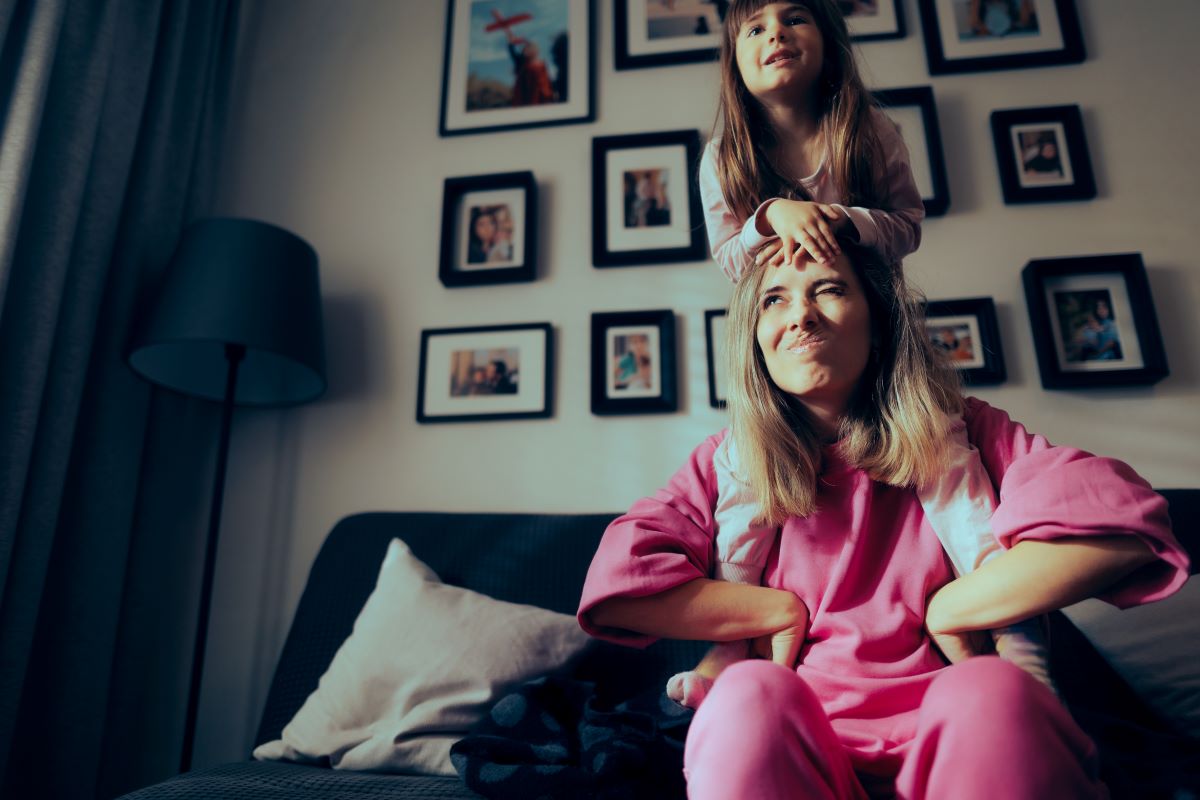 A child sitting on their parent's shoulders.